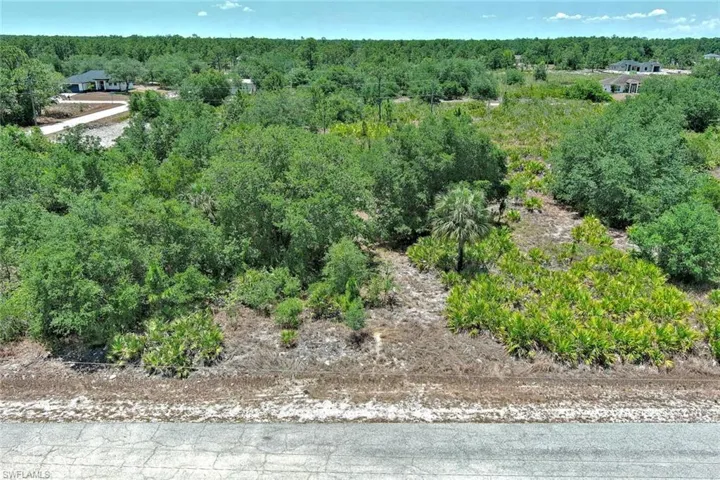 View of property location with a heavily wooded area