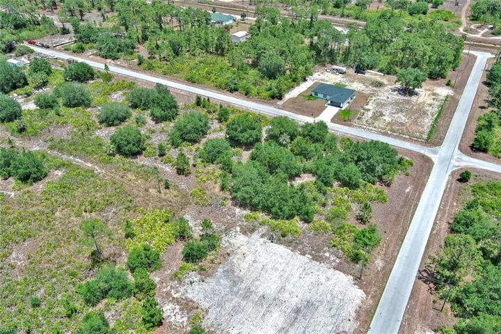Aerial view of property and surrounding area with a tree filled landscape