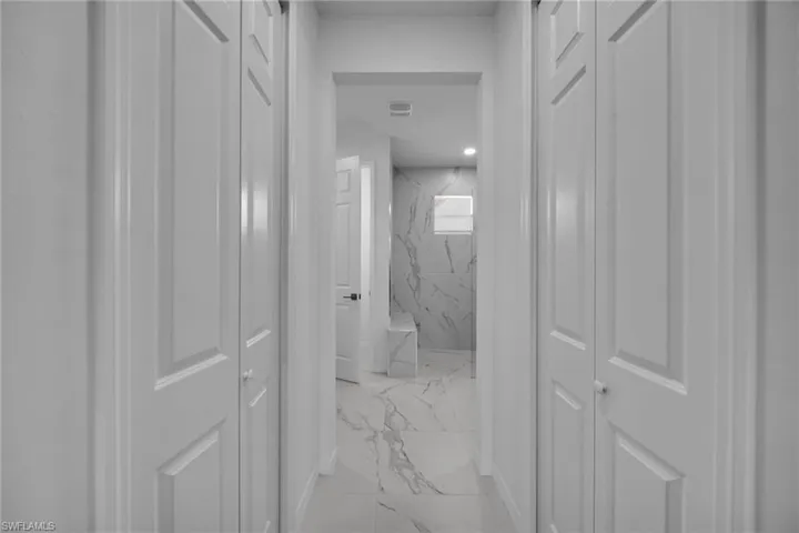 Hallway featuring white bi-fold doors and a ceiling-mounted light fixture