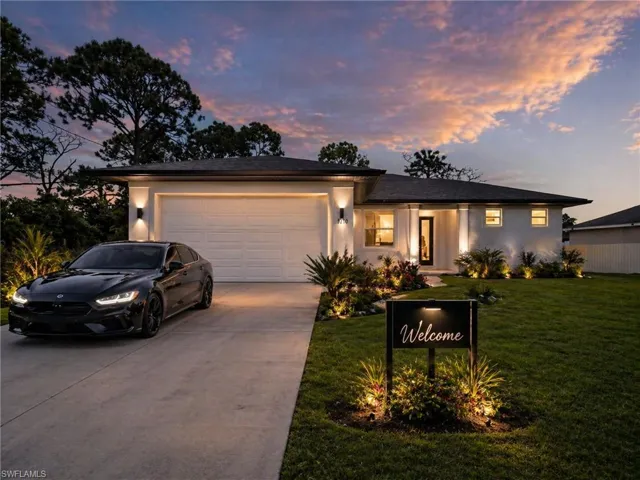 Contemporary exterior showcasing a two-car garage, concrete driveway, and front lawn