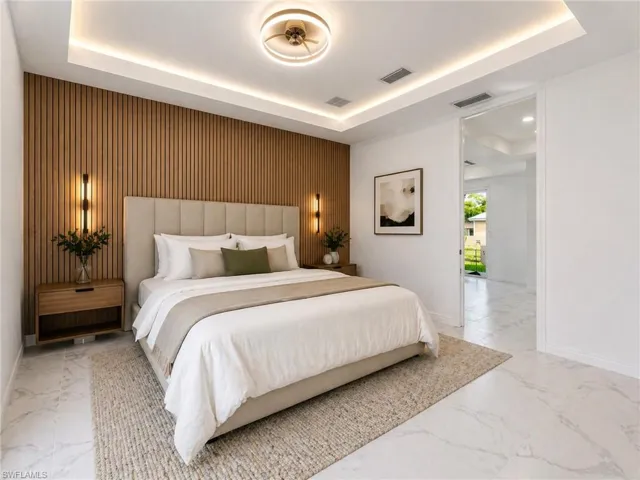Contemporary bedroom featuring a wood slat accent wall, recessed lighting, a modern ceiling fixture, and large format tile flooring