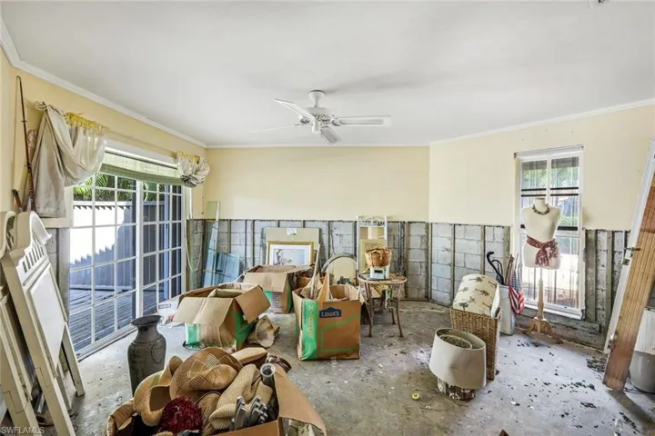 Miscellaneous room featuring a ceiling fan, a healthy amount of sunlight, and ornamental molding