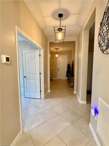 Hallway featuring light tile patterned flooring and baseboards