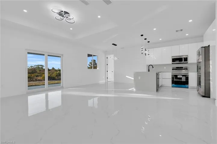 Unfurnished living room featuring recessed lighting and light marble finish flooring