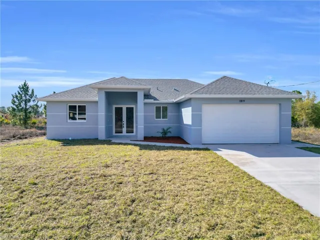 Ranch-style house featuring french doors, stucco siding, a front lawn, and a shingled roof