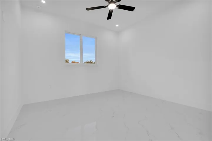 Spare room with ceiling fan, recessed lighting, and marble look tile flooring
