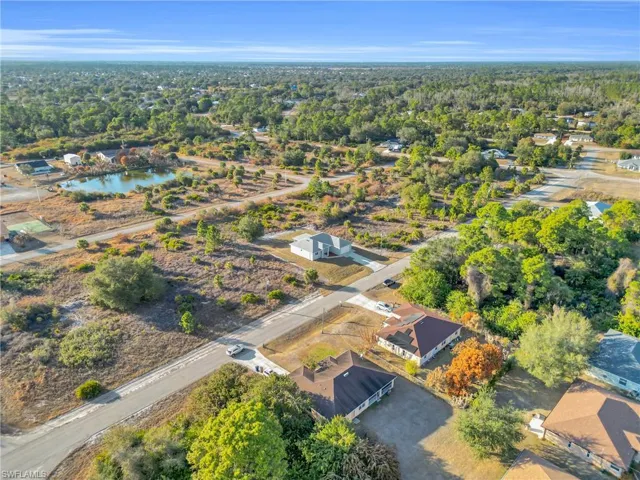 Aerial view of property and surrounding area featuring nearby suburban area