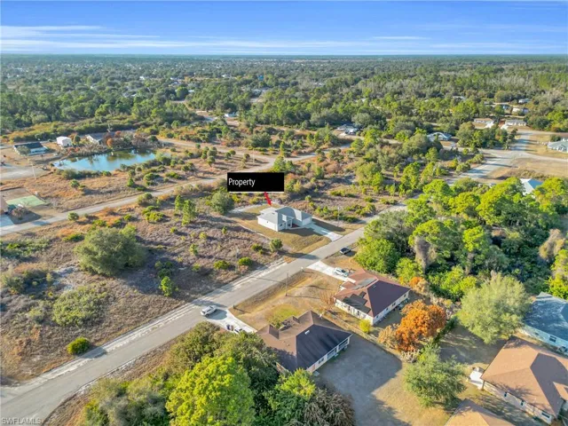 Aerial view of property and surrounding area featuring nearby suburban area