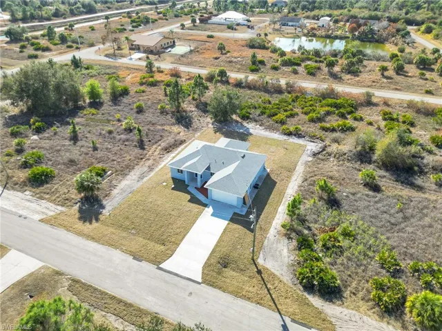 Aerial view of property and surrounding area featuring a nearby body of water