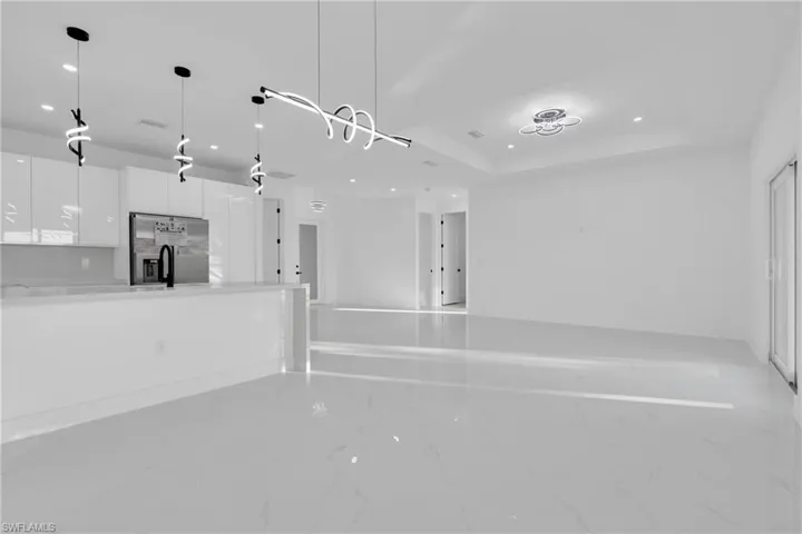 Unfurnished living room featuring recessed lighting and a raised ceiling