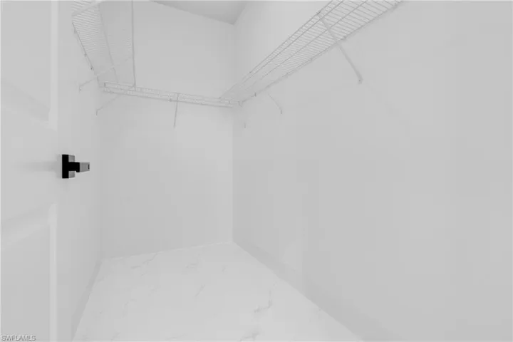 Walk in closet with light marble finish flooring