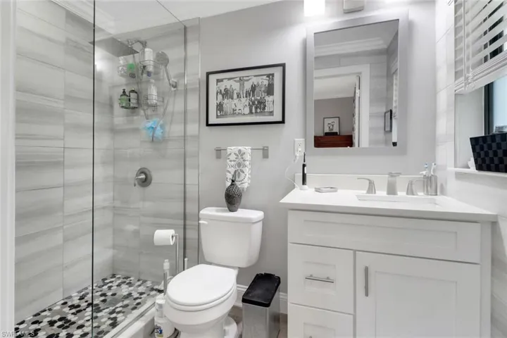 Full bathroom with a stall shower, vanity, and crown molding