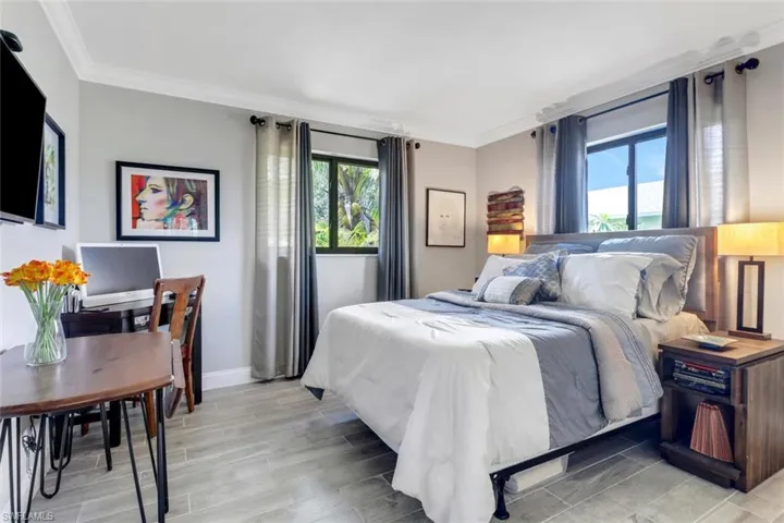Bedroom with ornamental molding and light wood-style floors