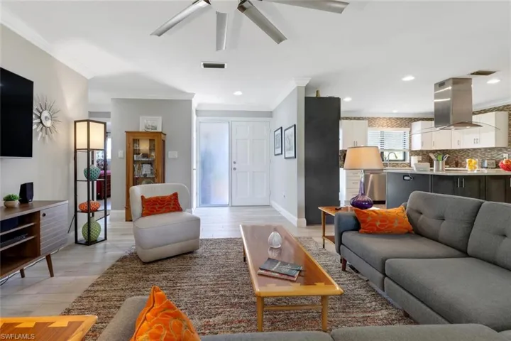 Living area featuring crown molding, a ceiling fan, light wood finished floors, and recessed lighting
