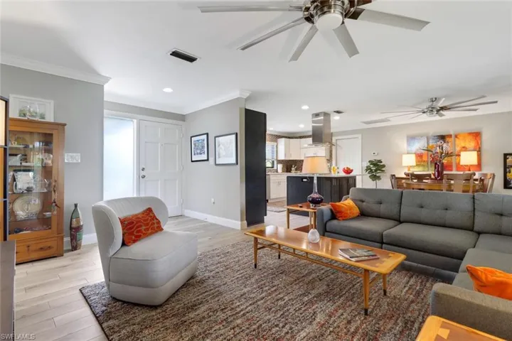 Living area featuring a ceiling fan, light wood-type flooring, ornamental molding, and recessed lighting