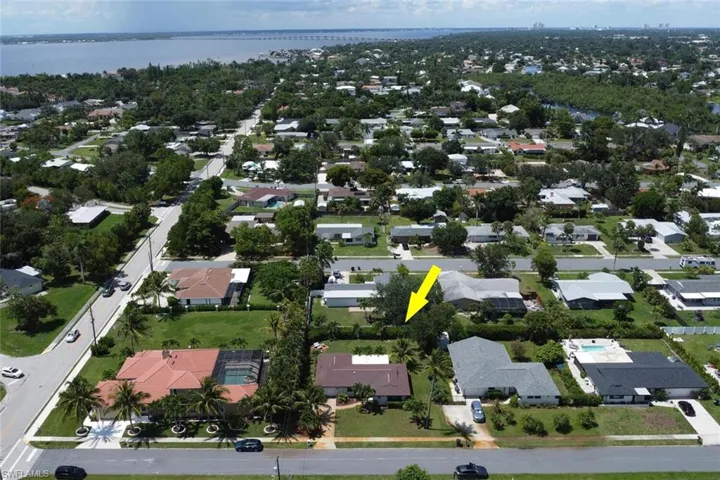 Aerial view of property and surrounding area with a large body of water and nearby suburban area
