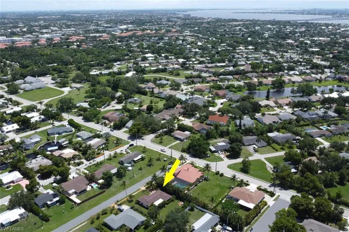 Aerial view of property and surrounding area featuring a nearby body of water and a notable bridge