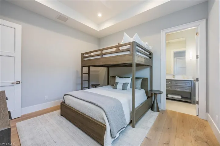 Bedroom with ensuite bath and light wood-type flooring