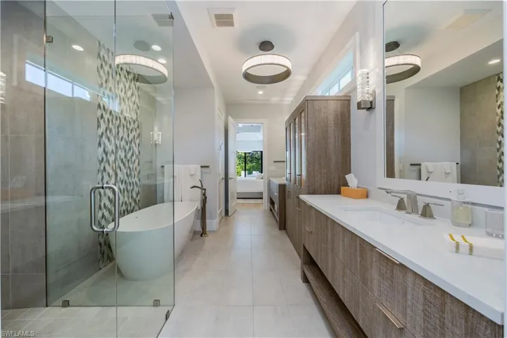 Bathroom with tile patterned floors, vanity, and plus walk in shower