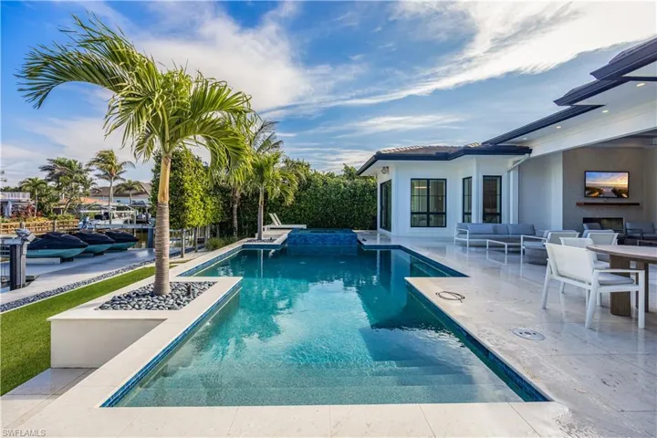 View of swimming pool with a patio area and an outdoor living space with a fireplace