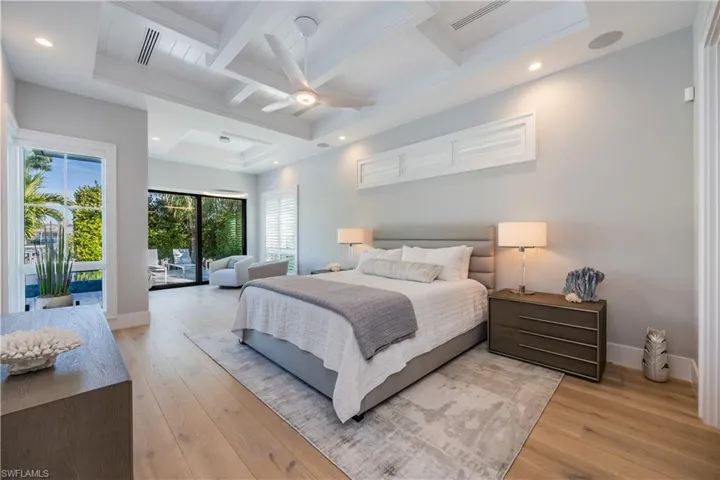 Bedroom with ceiling fan, beam ceiling, light hardwood / wood-style floors, and access to outside