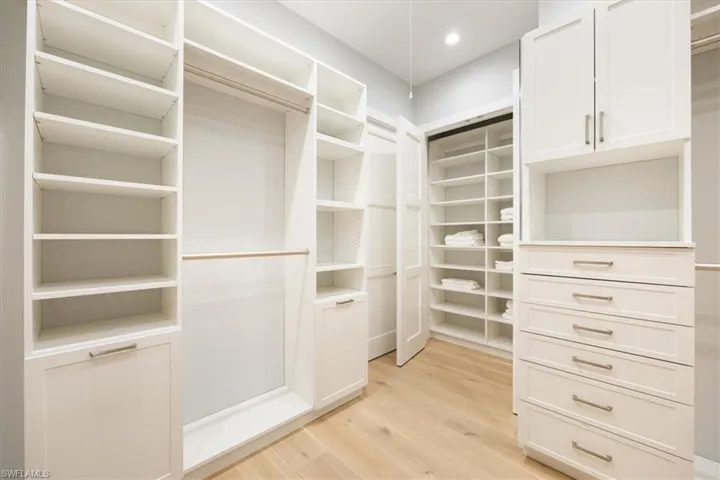 Spacious closet with light hardwood / wood-style flooring