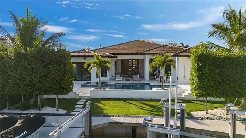 Back of house with a patio and a lawn
