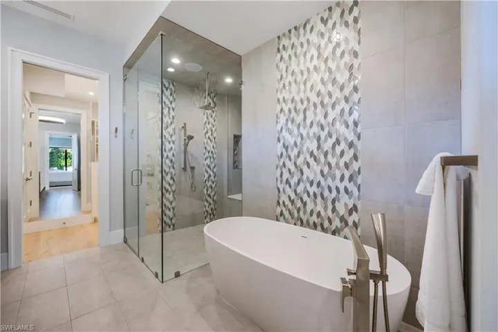 Bathroom featuring separate shower and tub, tile walls, and tile patterned floors
