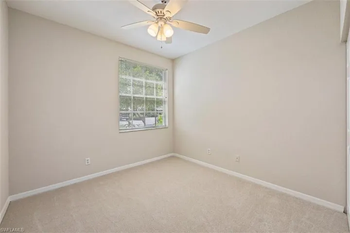 Empty room featuring light carpet and a ceiling fan