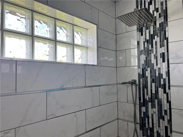 Luxury fixtures featuring a tile shower