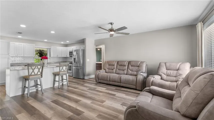 Living room featuring ceiling fan and light hardwood / wood-style flooring