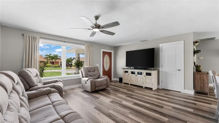 Living room with ceiling fan and hardwood / wood-style flooring