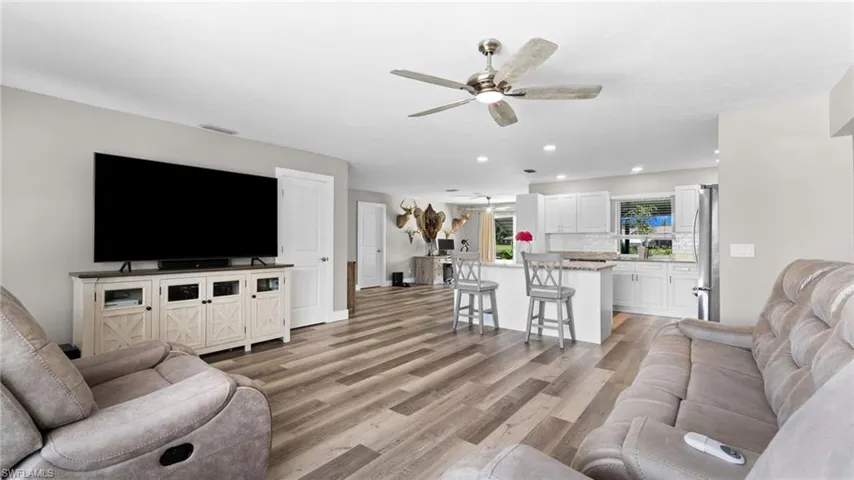 Living room with ceiling fan and light wood-type flooring