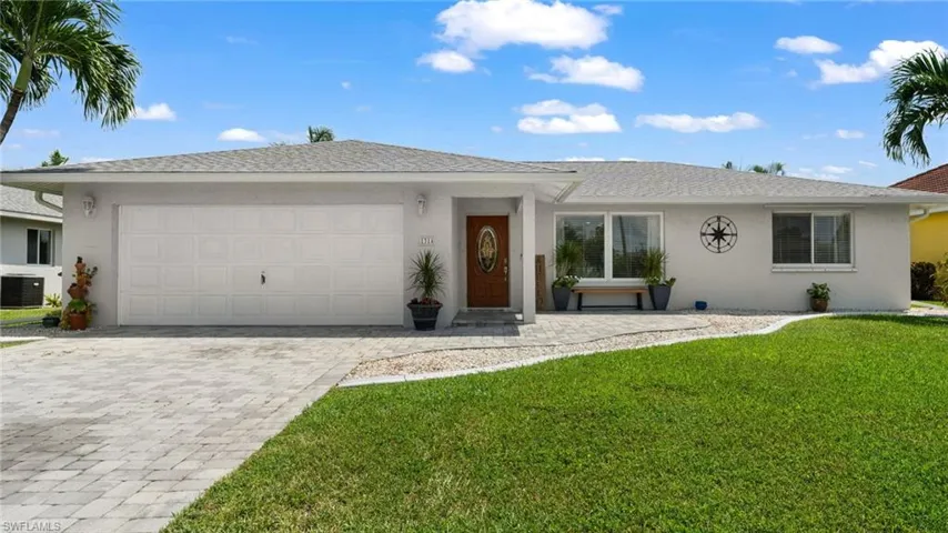 Ranch-style house featuring central AC unit, a garage, and a front yard