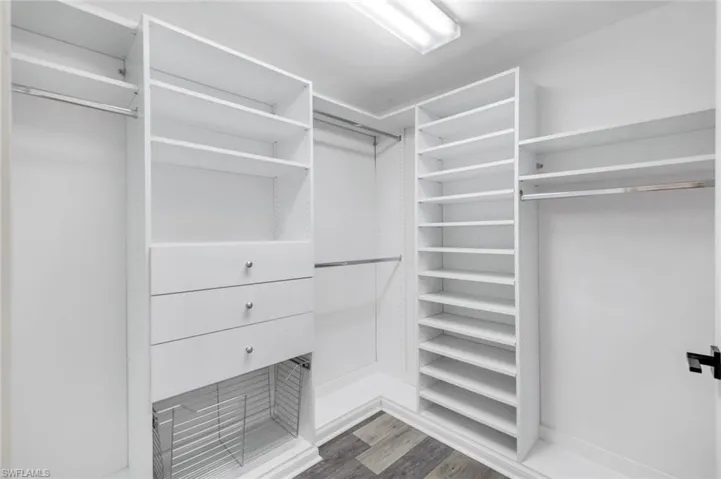 Walk in closet with custom build it closet drawers and shelving