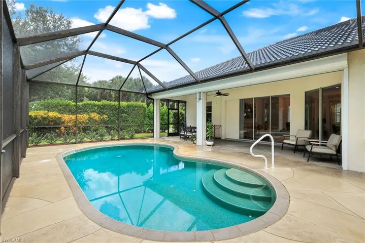 Swimming pool with a cage, a lanai, and a ceiling fan.  Owner is leaving outside grill