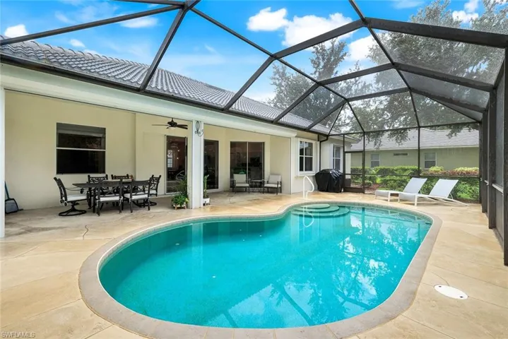 Outdoor pool featuring a patio, outdoor dining area, a lanai, a sunroom, and a ceiling fan