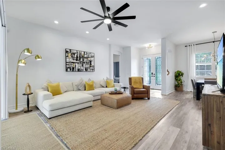 Living area with recessed lighting, light wood-style LVT flooring, french doors, arched walkways, and ceiling fan