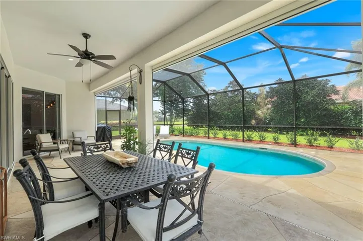 Swimming pool featuring a patio area, hurricane electric enclosure, a ceiling fan, and outdoor dining area with grill