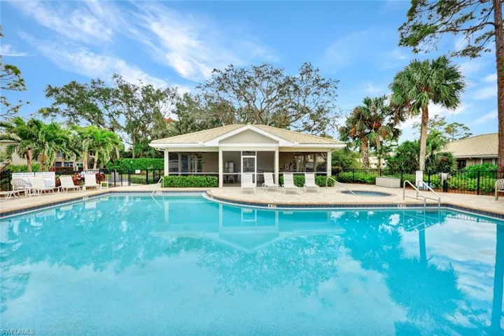 View of one of the pools with a community hot tub and screened enclosure