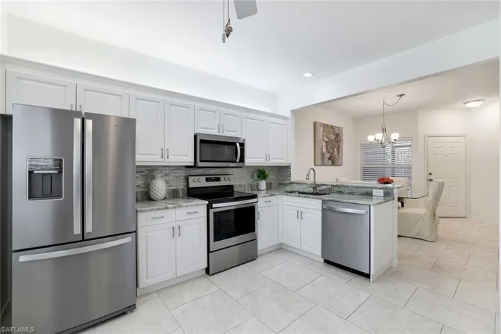 Kitchen white cabinetry and stainless steel appliances, granite countertop