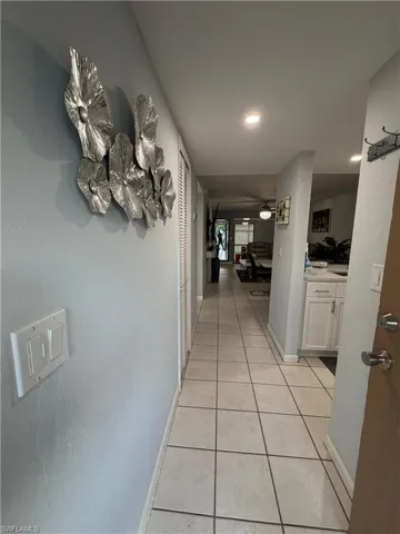 Hallway featuring square tile flooring and recessed lighting