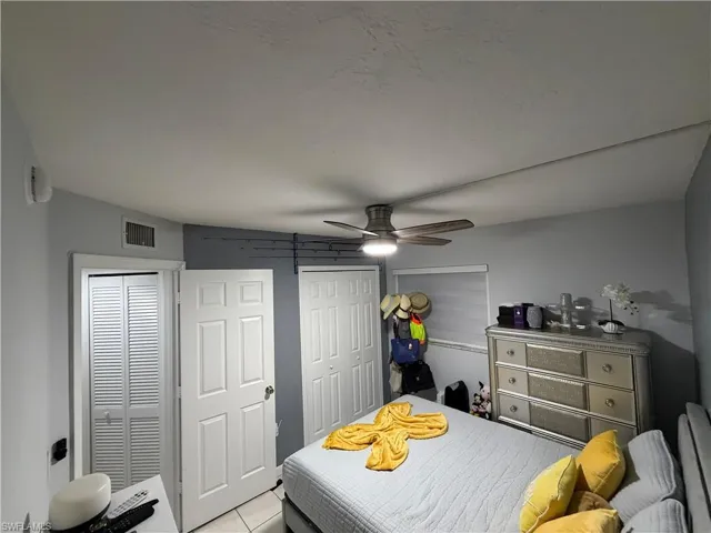 Interior room featuring a ceiling fan with integrated lighting, a paneled door, and louvered bifold closet doors