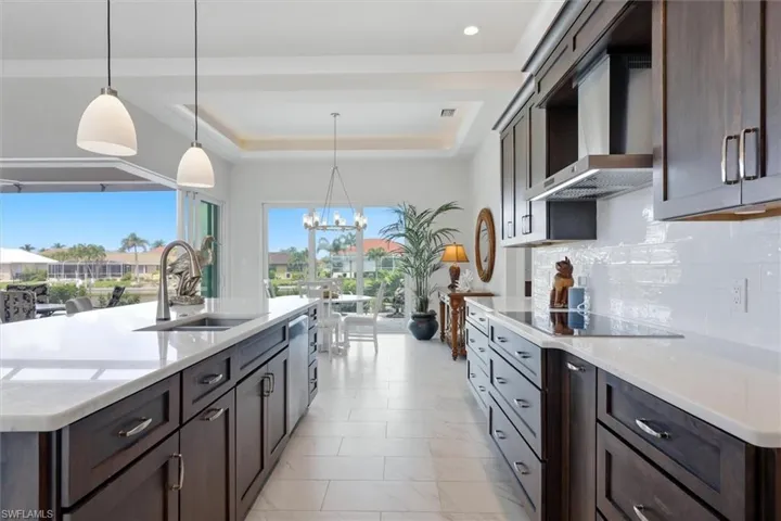 Gourmet kitchen with dark wood cabinetry, white countertops, tile backsplash, and stainless steel appliances
