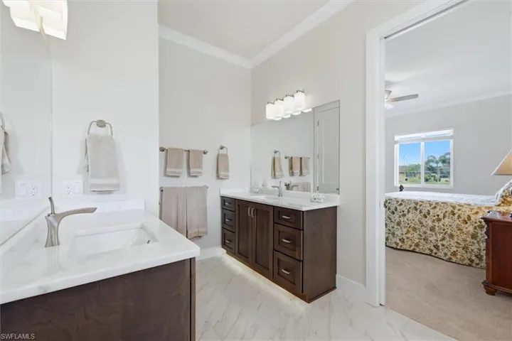 Dual vanity featuring white countertops, undermount sinks, and wood-finish cabinetry