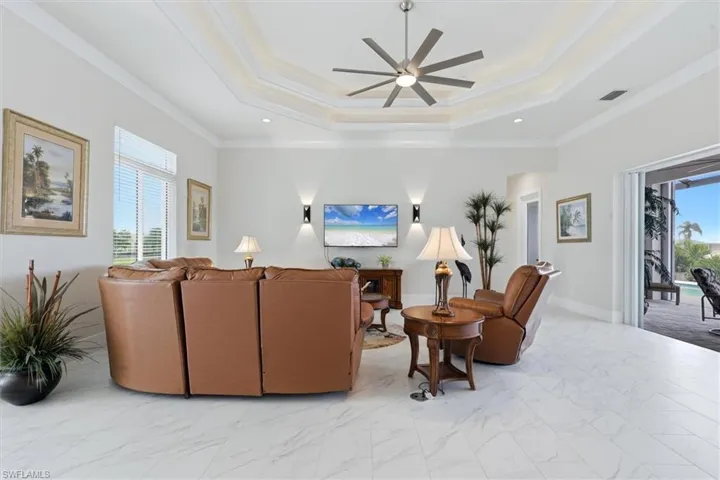 Tray ceiling with recessed lighting and a ceiling fan, light-toned wall paint, large format tile flooring, and sliding glass panel doors