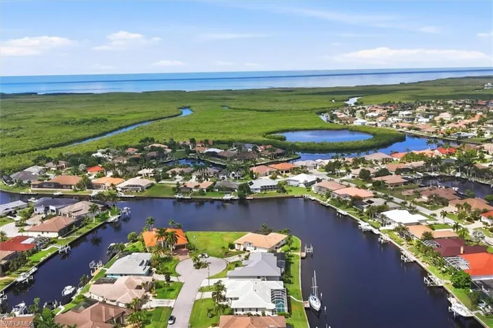 Canal-front homes with direct water access, surrounded by lush natural landscaping and open water