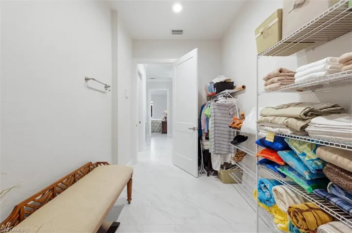 White interior walls with a single panel door, recessed lighting, and wire shelving storage system