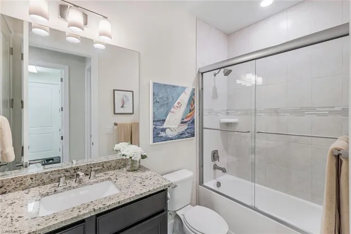 2nd full bathroom with shower / bath combination with glass door, toilet, and vanity