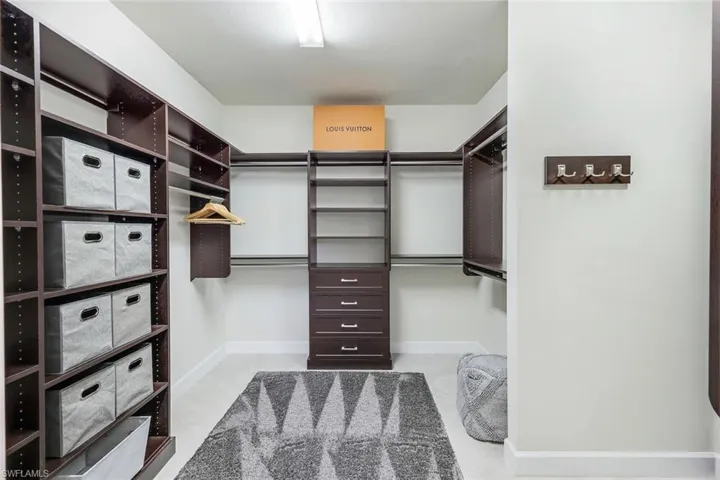 Primary bedroom suite walk in closet with closet organizers